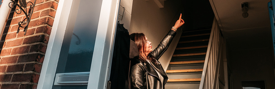 Vitalija wijst naar boven in haar huis