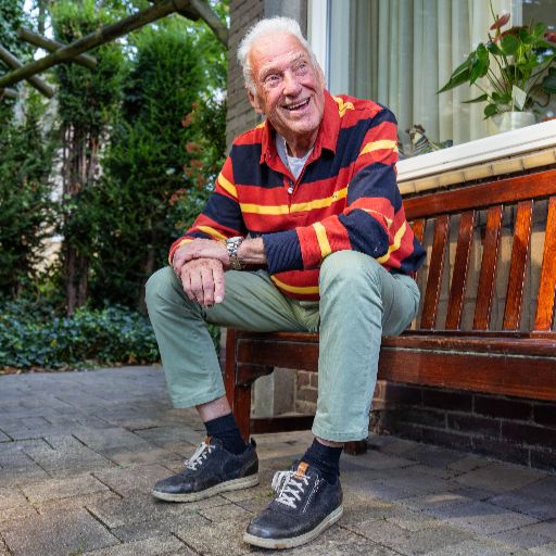 man op bankje voor huis